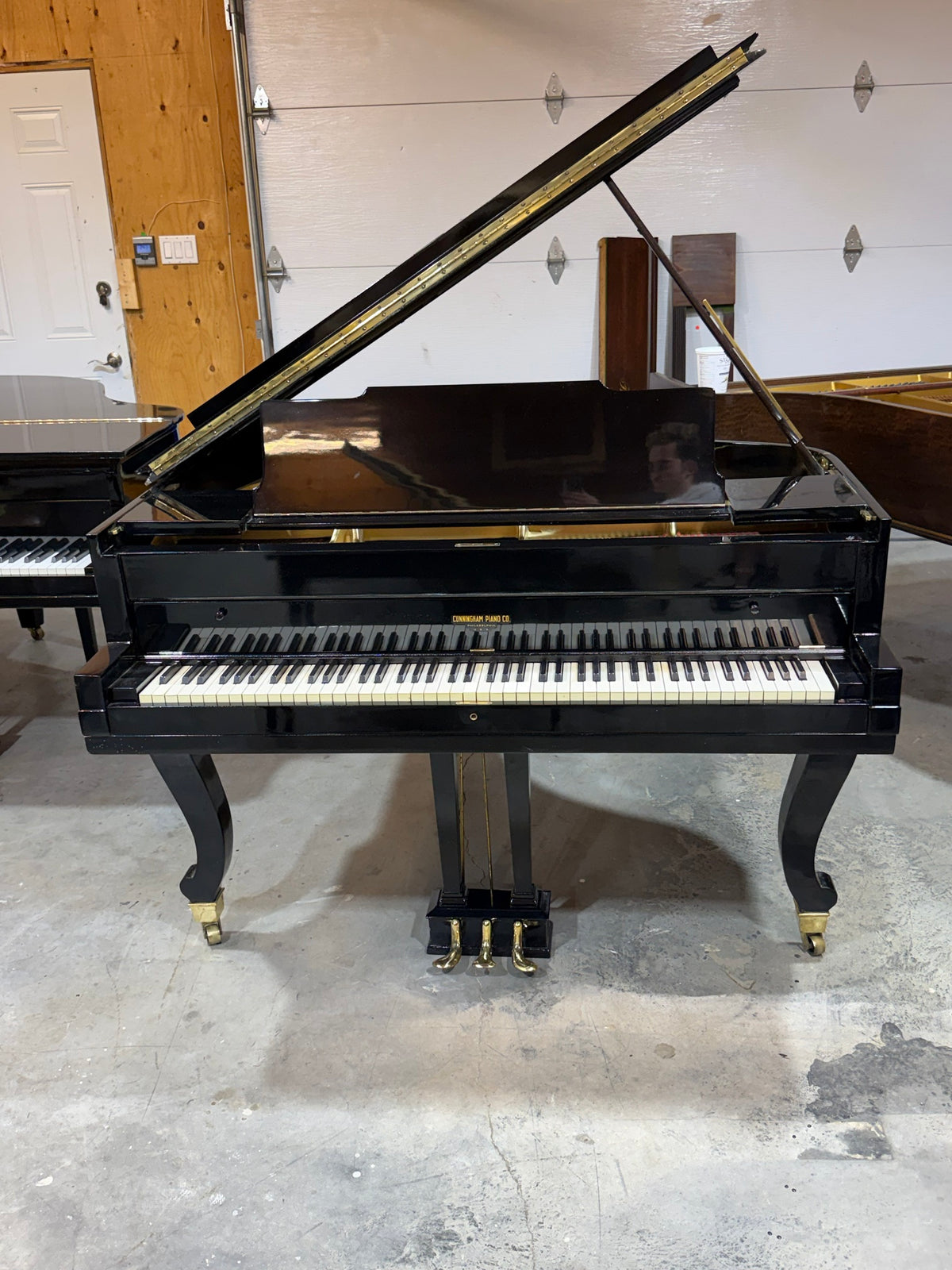 Front view of the Cunningham grand piano, lid open